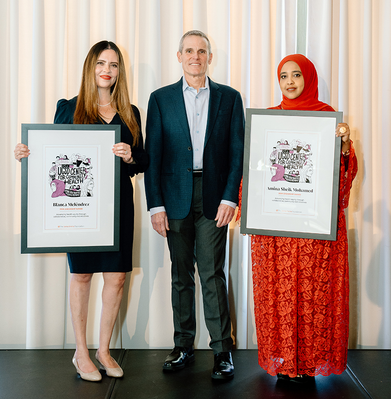 Blanca Meléndrez and Amina Sheik Mohamed hold framed certificates next to Don Howard, CEO of Irvine Foundation.
